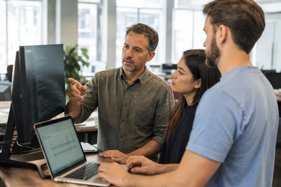 Engineering manager and two developers comparing AI coding tool costs per developer